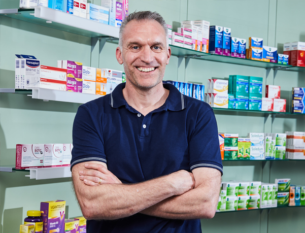 Moderne Innenansicht der Löwen-Apotheke, Apothekerin steht am PC und telefoniert.